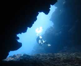 Dive guide exits swimthrough at bigfoot sundance diving the coral coast fiji islands diveplanit feature