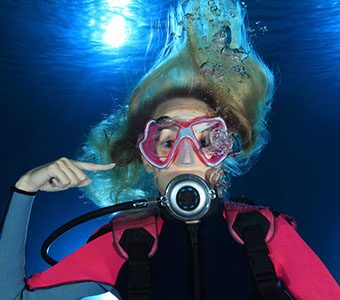 Femal diver pointing to ear shutterstock 191216096 feature